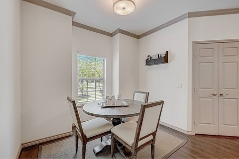 A dining room with a round table and chairs.