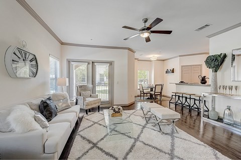 A living room with a white couch and a glass coffee table.