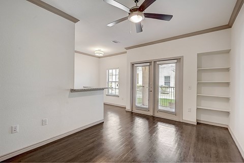 A room with a ceiling fan and wooden flooring.