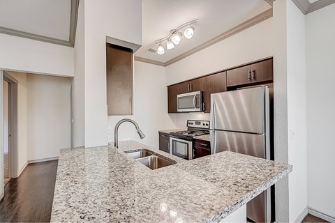 A kitchen with granite countertops and stainless steel appliances.