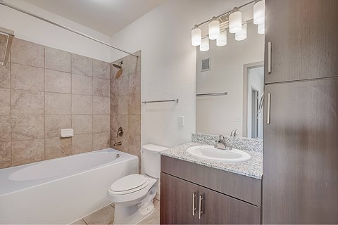 A bathroom with a tub, toilet, and sink.