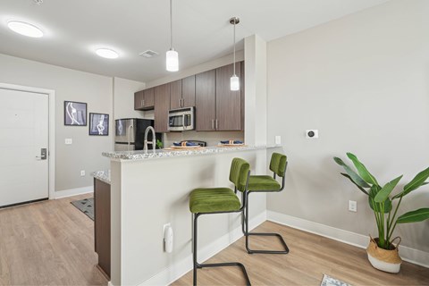 A kitchen with a green chair and a plant.
