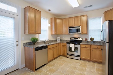 A kitchen with wooden cabinets and a black refrigerator.