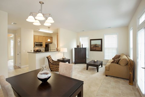 A well-lit living room with a brown table and a brown couch.