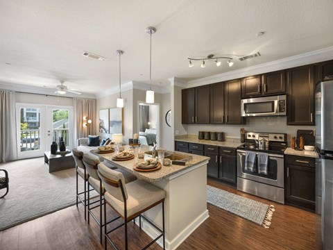 A modern kitchen with dark brown cabinets and stainless steel appliances.