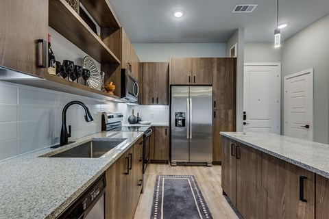 A kitchen with wooden cabinets and a granite countertop.