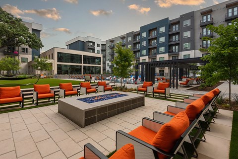 An outdoor seating area with fire pit at The Academic in Dallas Texas