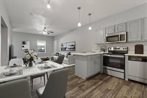A modern kitchen with a dining table set for two.