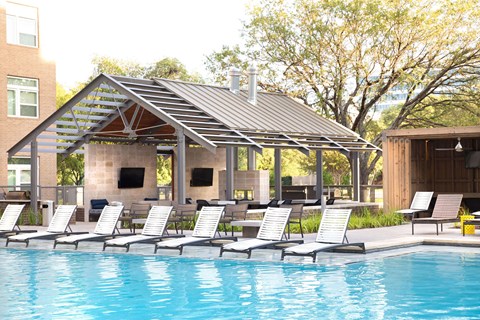 swimming pool with lounge chairs and a pool house with a pool