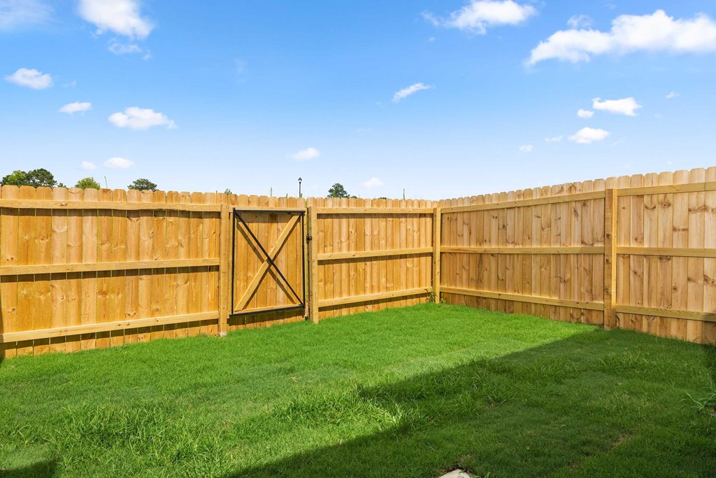 a wooden fence in a backyard with grass