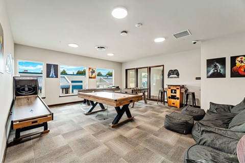 A room with a pool table, a couch, and a TV.