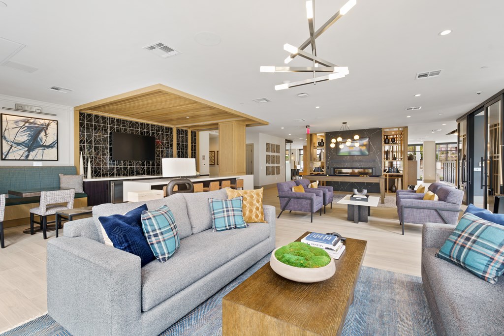 A modern living room with a grey couch and a wooden coffee table.