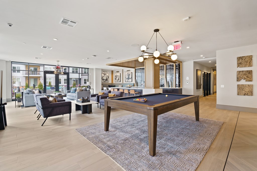A room with a pool table and a view of the outside.