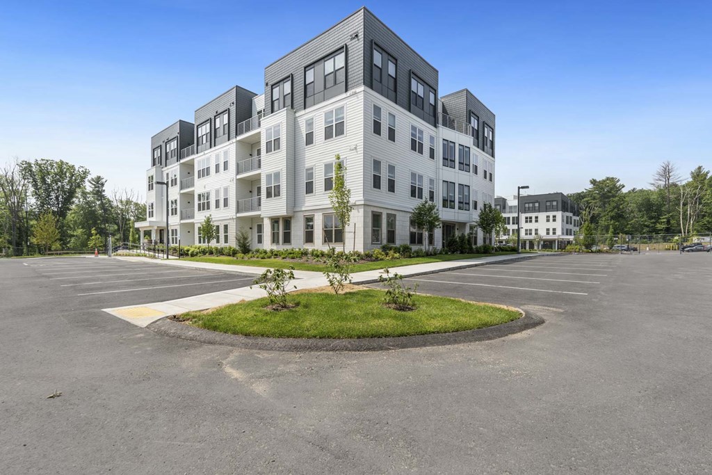 A large, modern building with a parking lot in front.