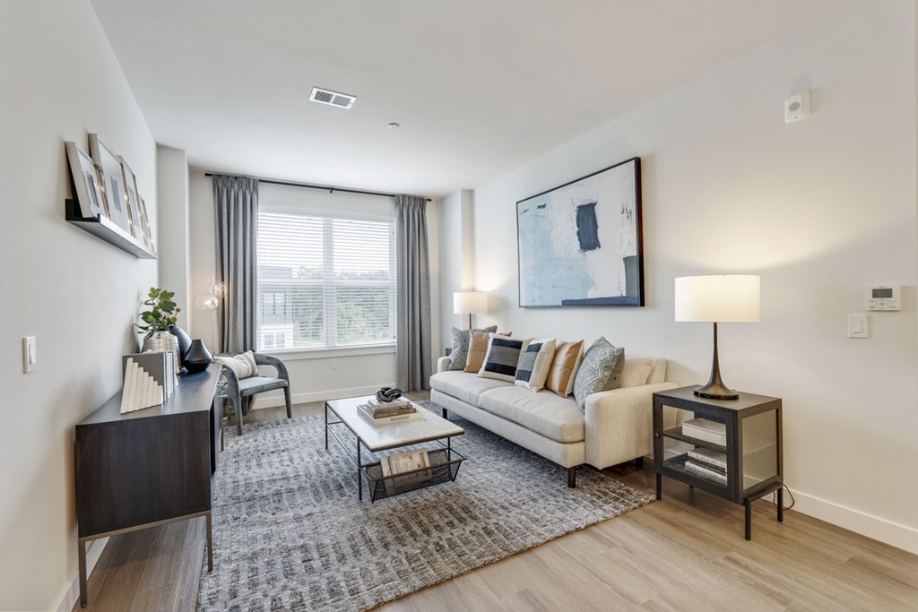 A living room with a couch, coffee table, and lamp.