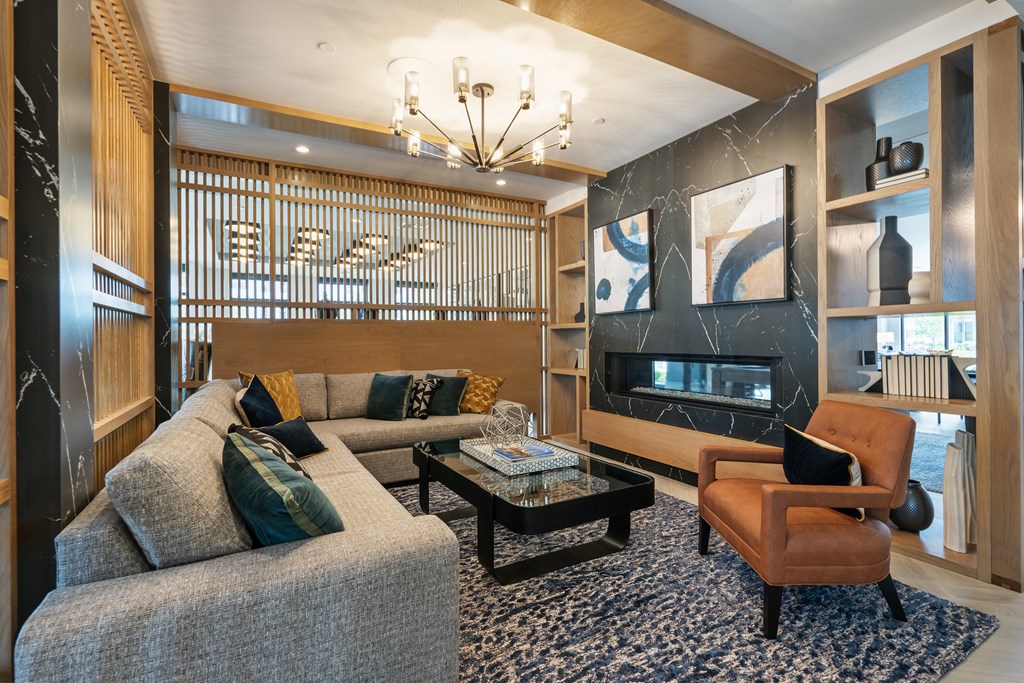 A living room with a grey couch, a brown chair, and a black coffee table.