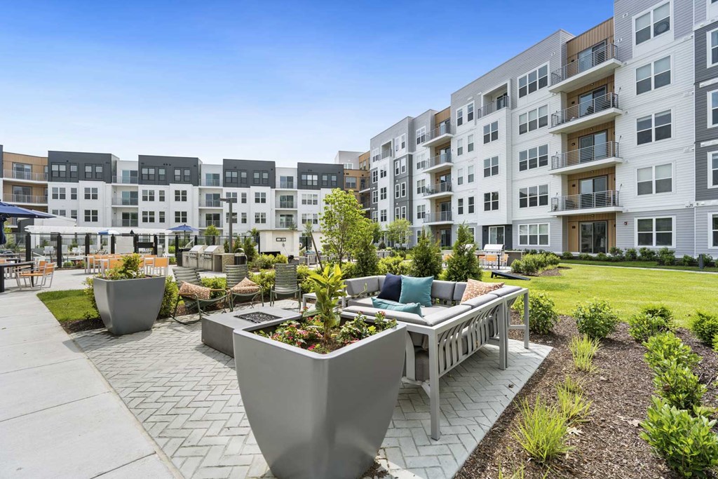A modern outdoor seating area with a large planter in the center.