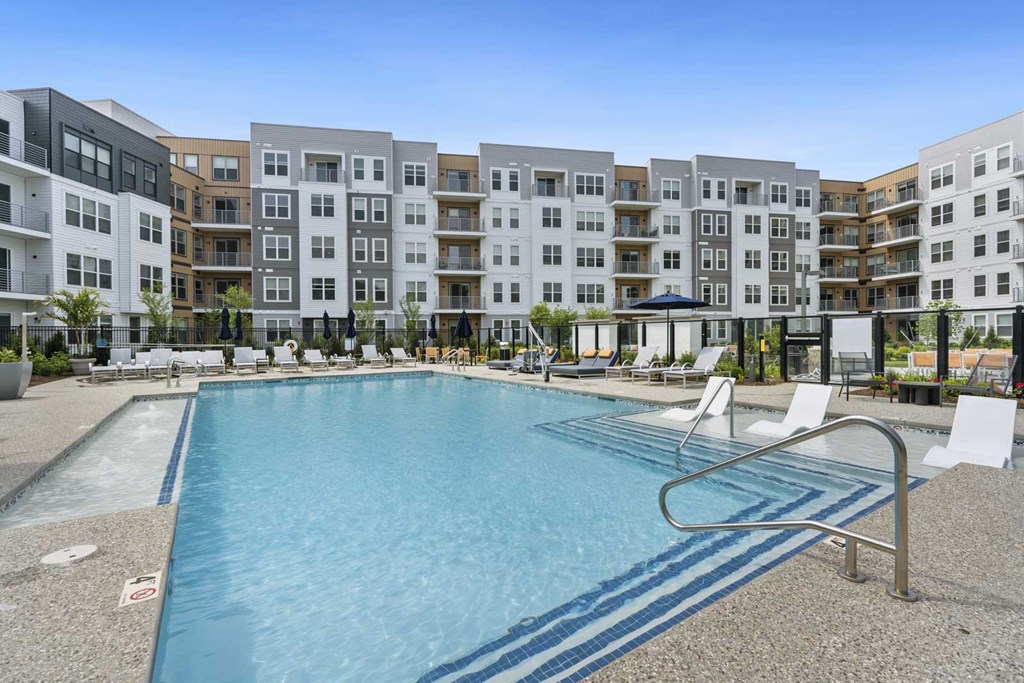 A swimming pool in front of apartment buildings.