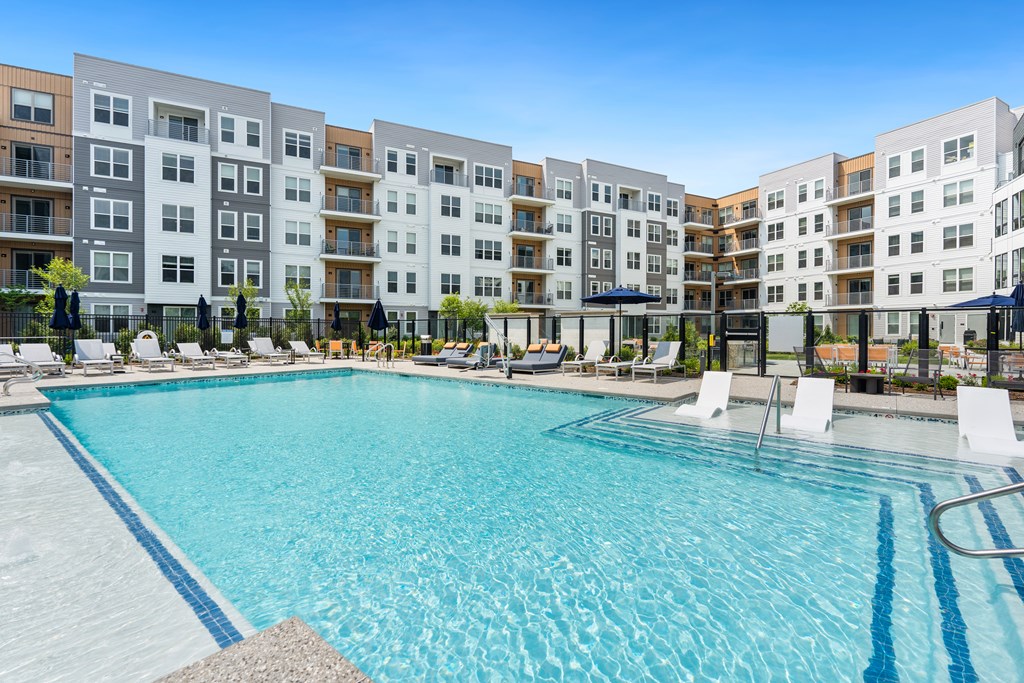 A large swimming pool in front of apartment buildings.