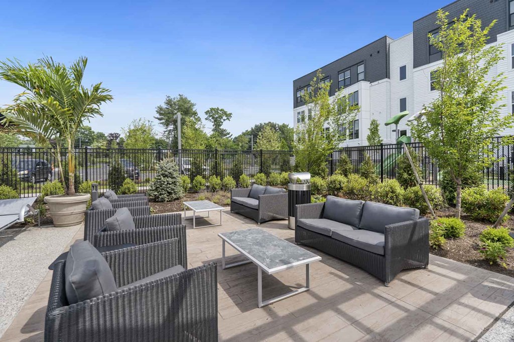 A black outdoor furniture set is placed on a patio.