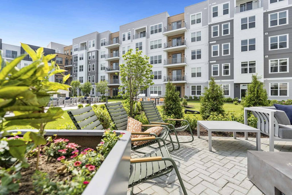 A modern apartment complex with a well-maintained outdoor seating area.