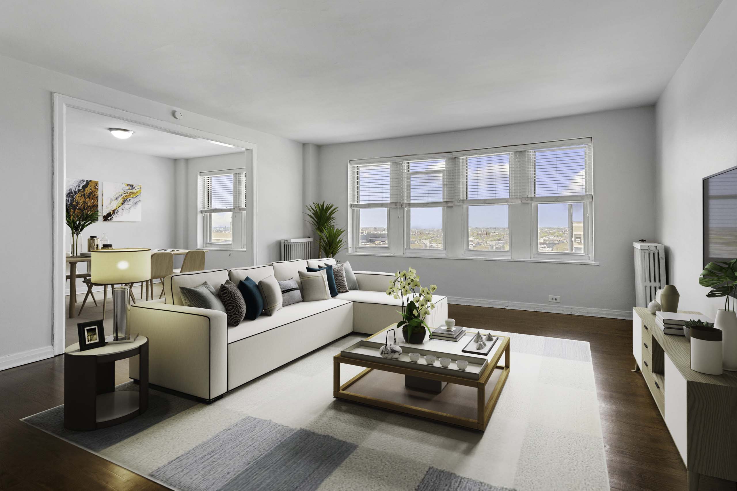 A living room with a large couch, a coffee table, and a window with a view of the beach.