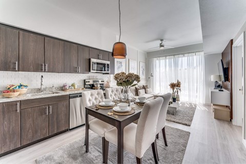 A modern kitchen with a dining table set for two.