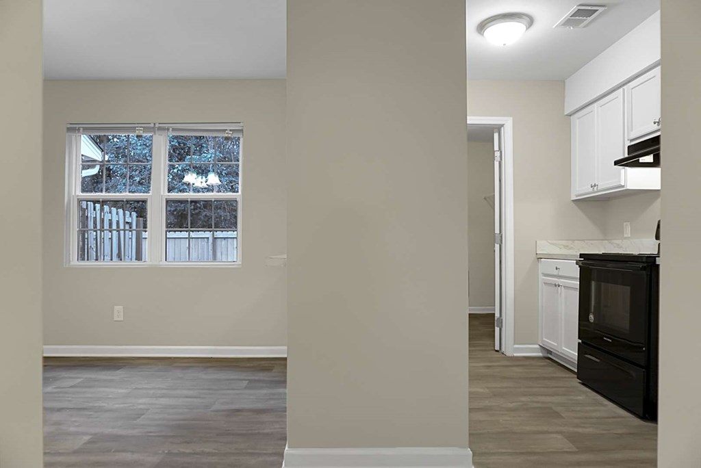 A kitchen with a black oven and white cabinets.