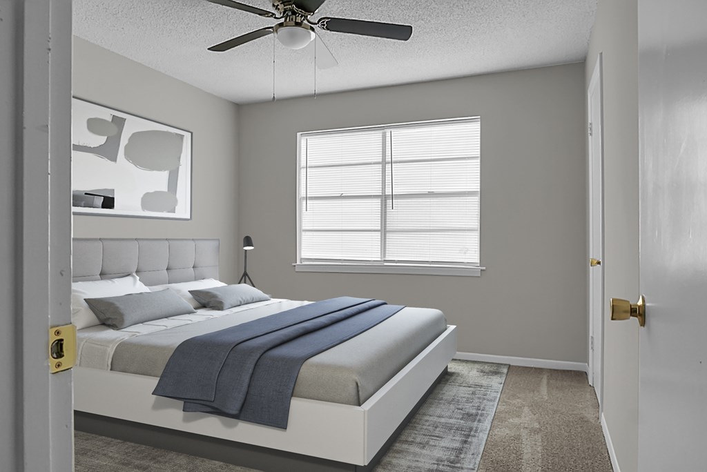 A bedroom with a bed, a ceiling fan, and a window.