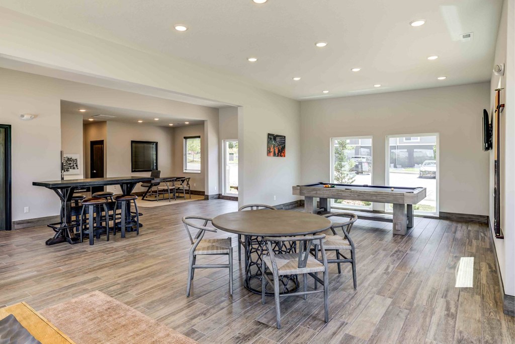 A spacious living room with a billiards table and a dining table.