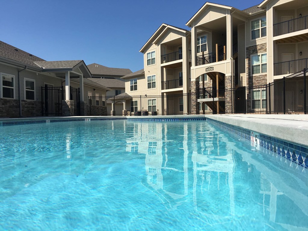 A swimming pool in front of apartment buildings.