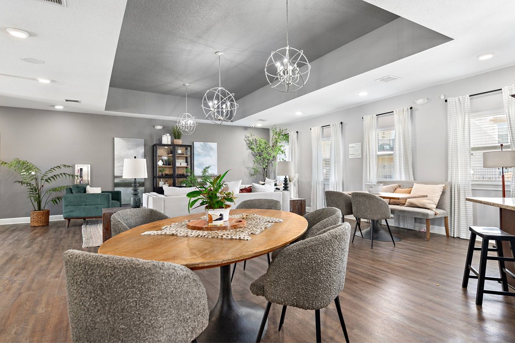 A modern dining room with a wooden table and grey chairs.