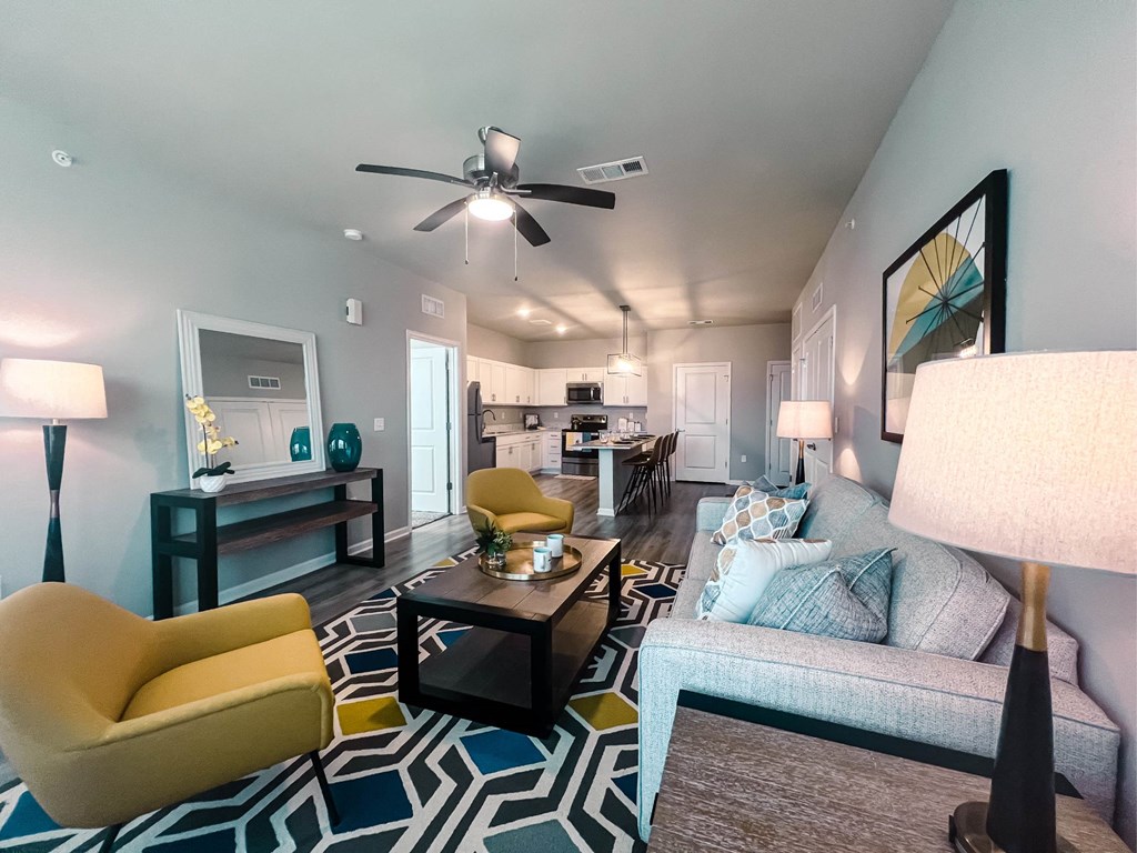 A living room with a yellow chair and a grey couch.