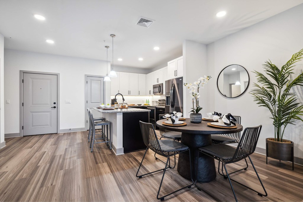 A modern dining room with a round table and chairs.
