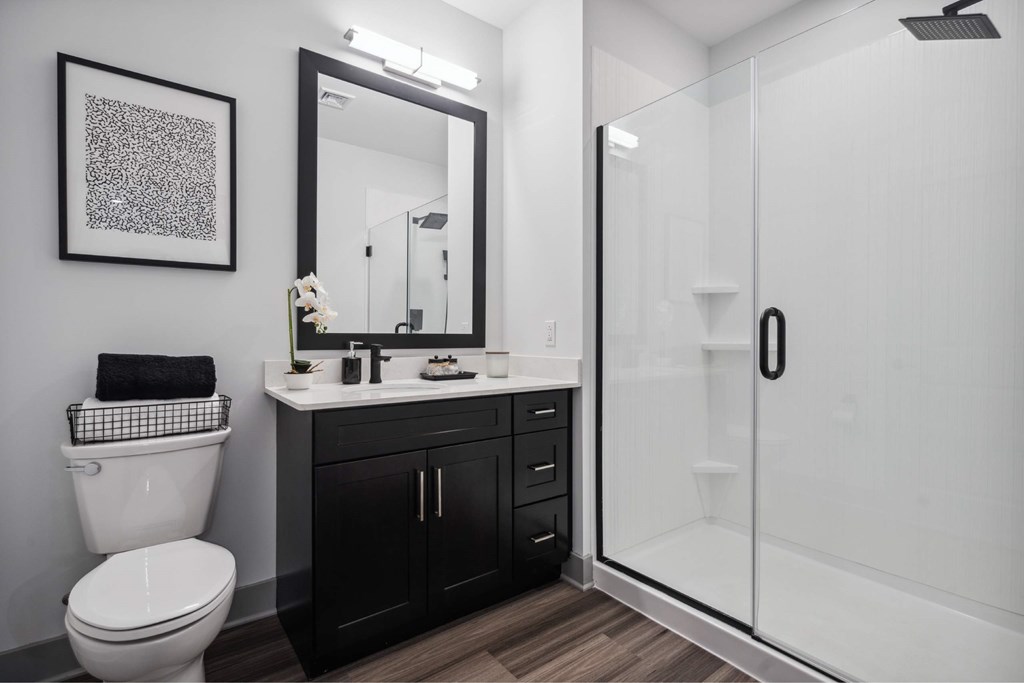 A bathroom with a toilet, sink, and mirror.