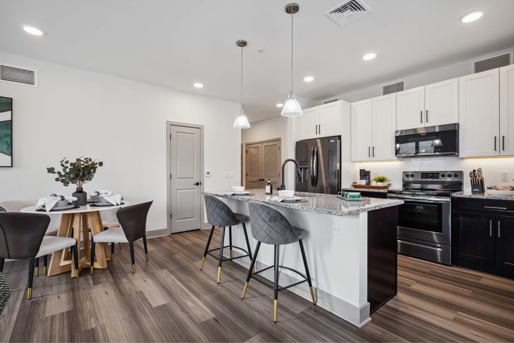 A modern kitchen with a dining table and chairs.