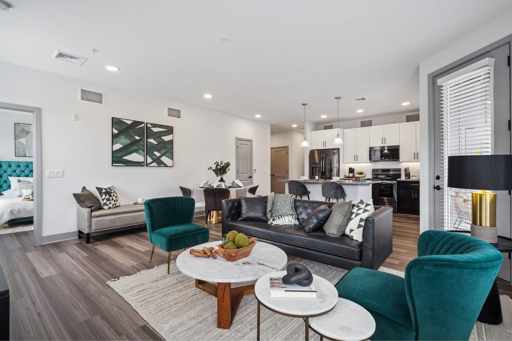 A modern living room with a green chair and a grey couch.