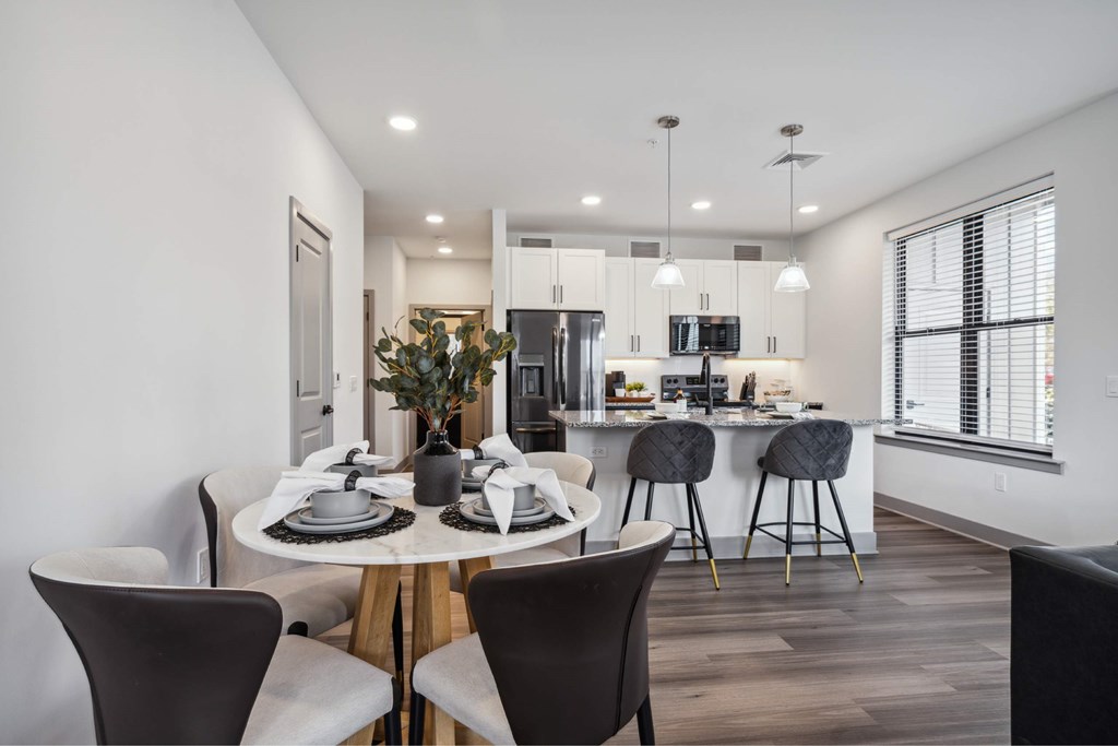 A modern kitchen with a dining table set for two.