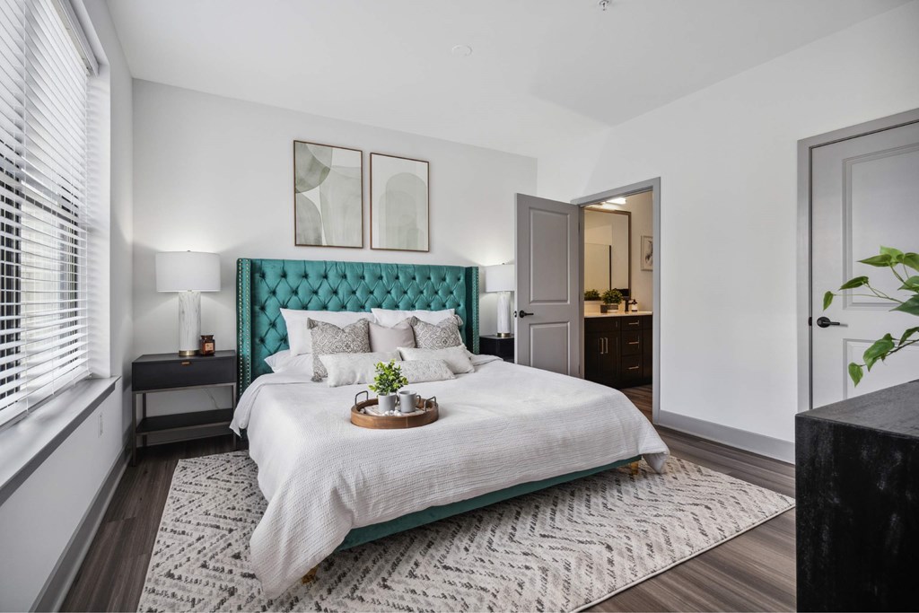 A bedroom with a large bed and a green headboard.