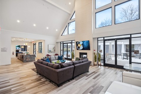 A modern living room with a brown couch and a fireplace.
