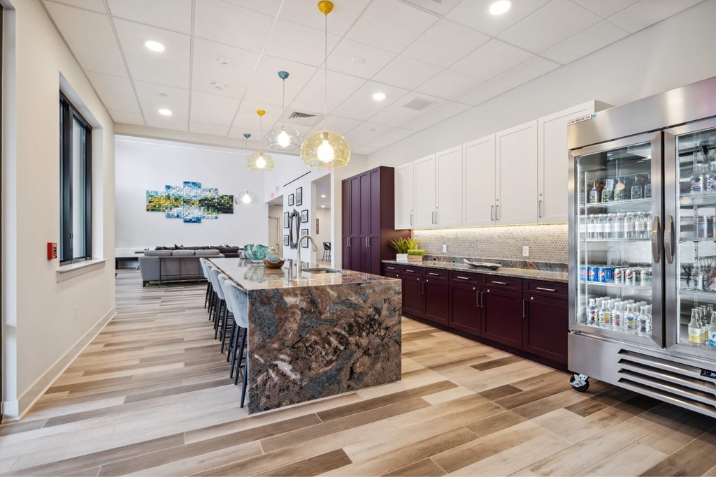 A kitchen with a marble island and wooden floors.