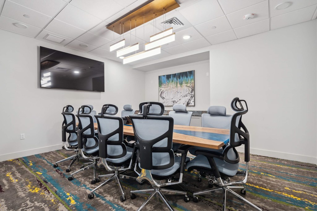 A conference room with a long table and chairs.