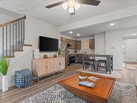 A living room with a wooden coffee table and a television on the wall.
