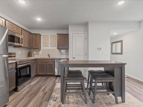 A kitchen with a table and chairs in the middle of the room.