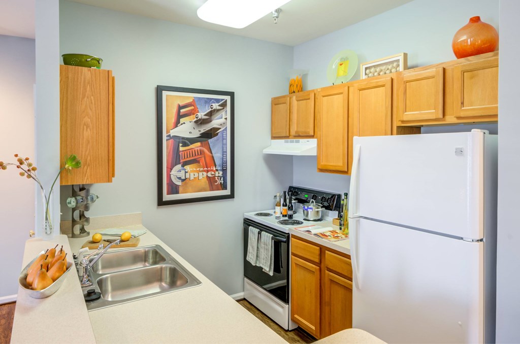 A kitchen with a white fridge, a sink and a microwave.