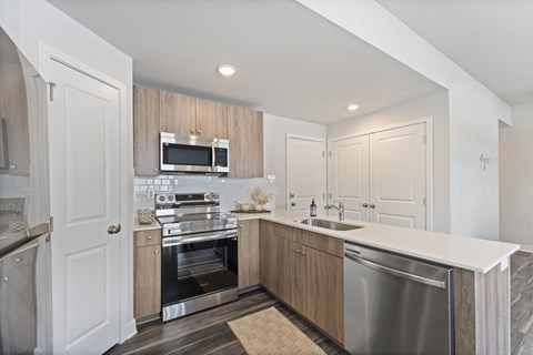A modern kitchen with a stainless steel dishwasher and oven.