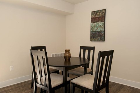 A dining room with a table and chairs.