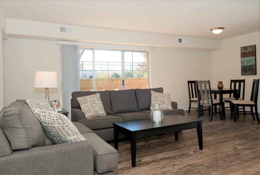 A living room with a grey couch, a black coffee table, and a lamp.