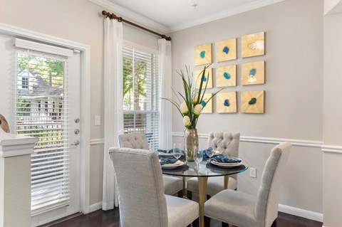 A dining room with a glass table and chairs.