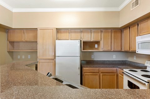 A kitchen with wooden cabinets and a white refrigerator.